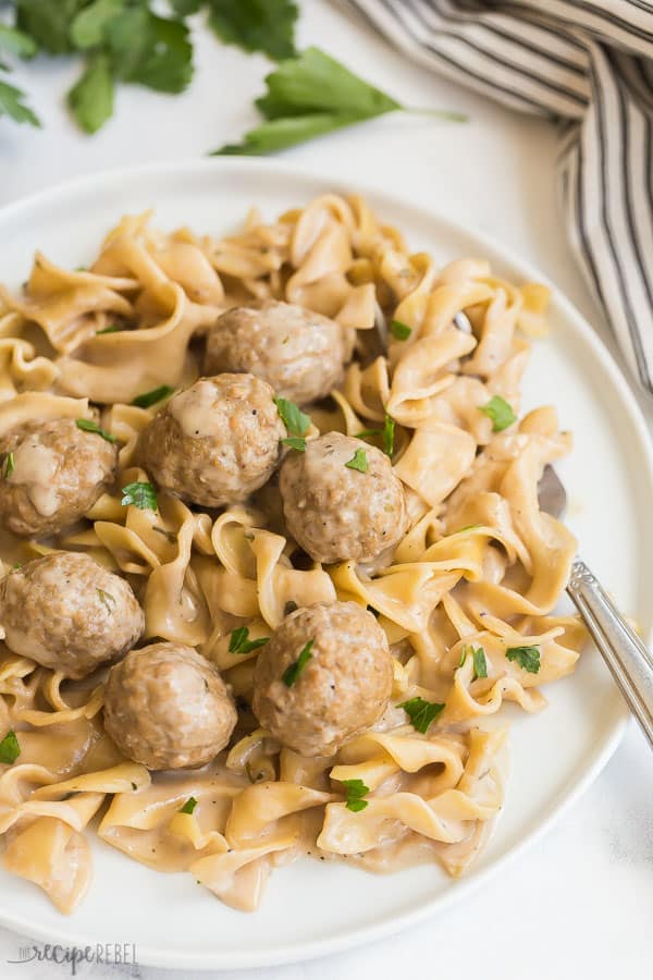 instant pot swedish meatballs and noodles on white plate with fresh parsley