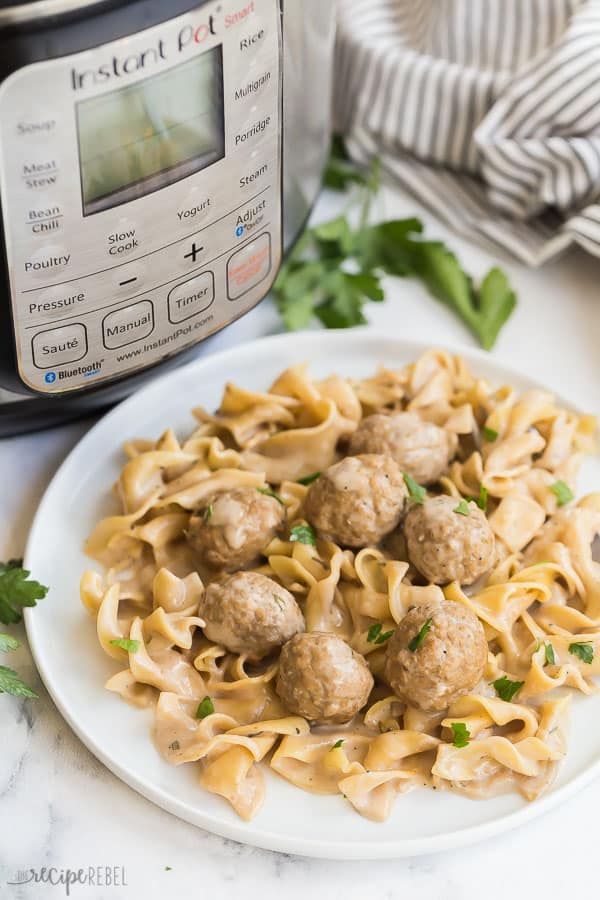 instant pot swedish meatballs with pressure cooker in the background on white plate