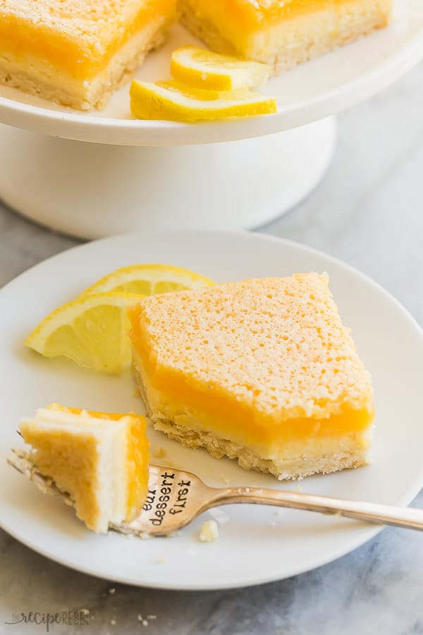 lemon cheesecake bars with fork on white plate with bite taken