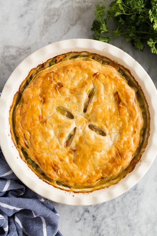 turkey pot pie overhead whole in white pie plate on marble background