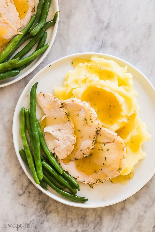 crockpot turkey breast with mashed potatoes and gravy overhead on grey marble background
