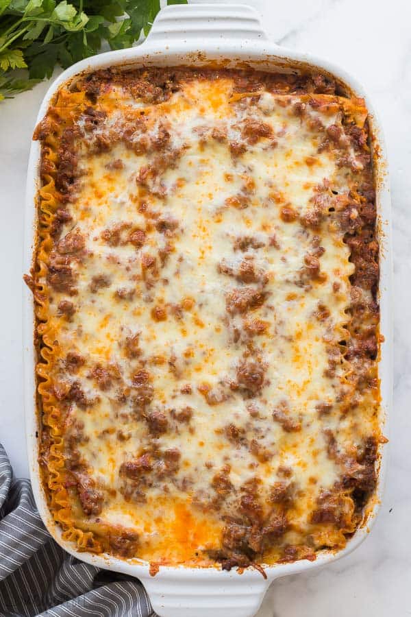easy lasagna recipe overhead in white baking dish on marble background