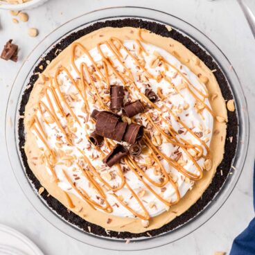 finished peanut butter pie with whipped cream peanut butter drizzle and chocolate shavings