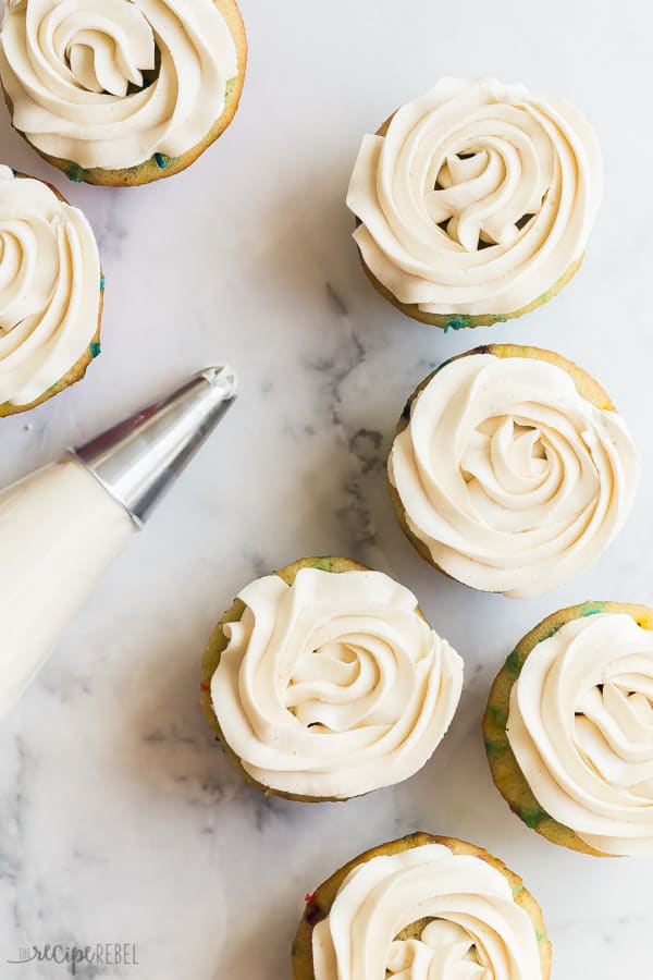 buttercream frosting on cupcakes overhead on marble background