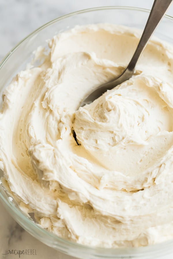 vanilla buttercream frosting in glass bowl with spoon stuck in