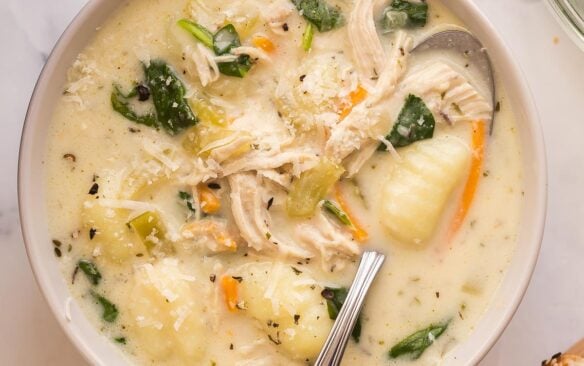 square image of bowl of chicken gnocchi soup with spoon