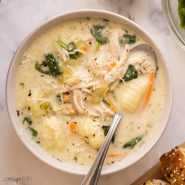 square image of bowl of chicken gnocchi soup with spoon
