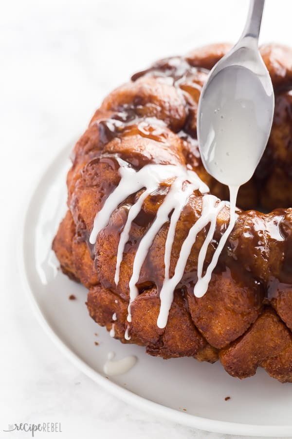 monkey bread with white glaze drizzling from spoon