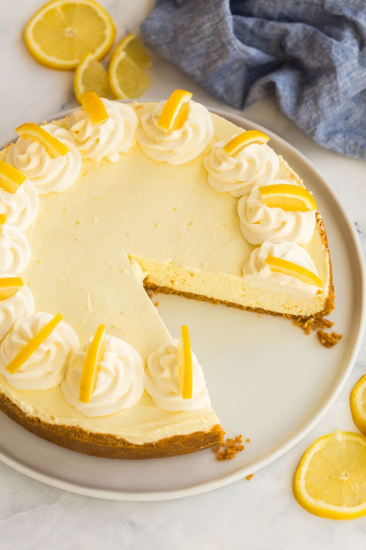 This No Bake Lemon Cheesecake is made with lemon juice and zest and no artificial flavors! It sets and slices perfectly and is even great frozen! #lemon #cheesecake #dessert | lemon recipes | no bake cheesecake | no bake desserts whole lemon cheesecake missing one piece