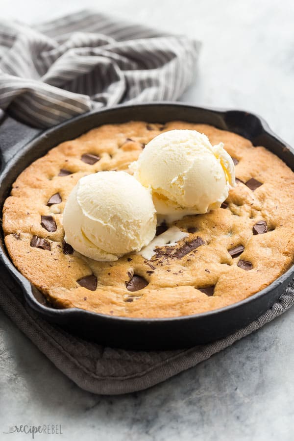 skillet cookie with ice cream scoops on grey marble background