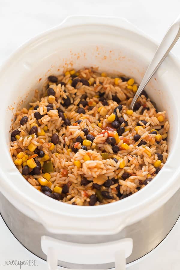 slow cooker burritos in white crockpot with spoon