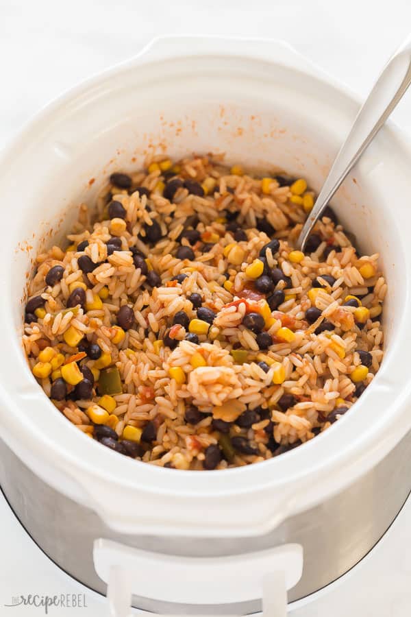These Slow Cooker Vegetarian Burritos are made with just 6 ingredients and 5 minutes prep! Lots of add in options, or make a burrito bowl! #mexican #recipes #slowcooker #crockpot #dinner slow cooker burritos in white crockpot with spoon