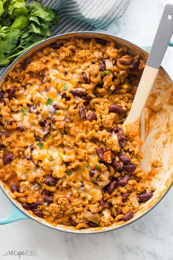 turkey chili mac and cheese overhead in pan with blue handles on marble