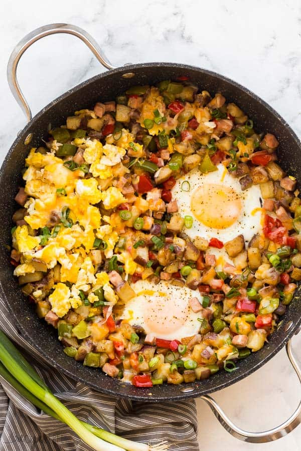 breakfast skillet in large black pan overhead with eggs two ways