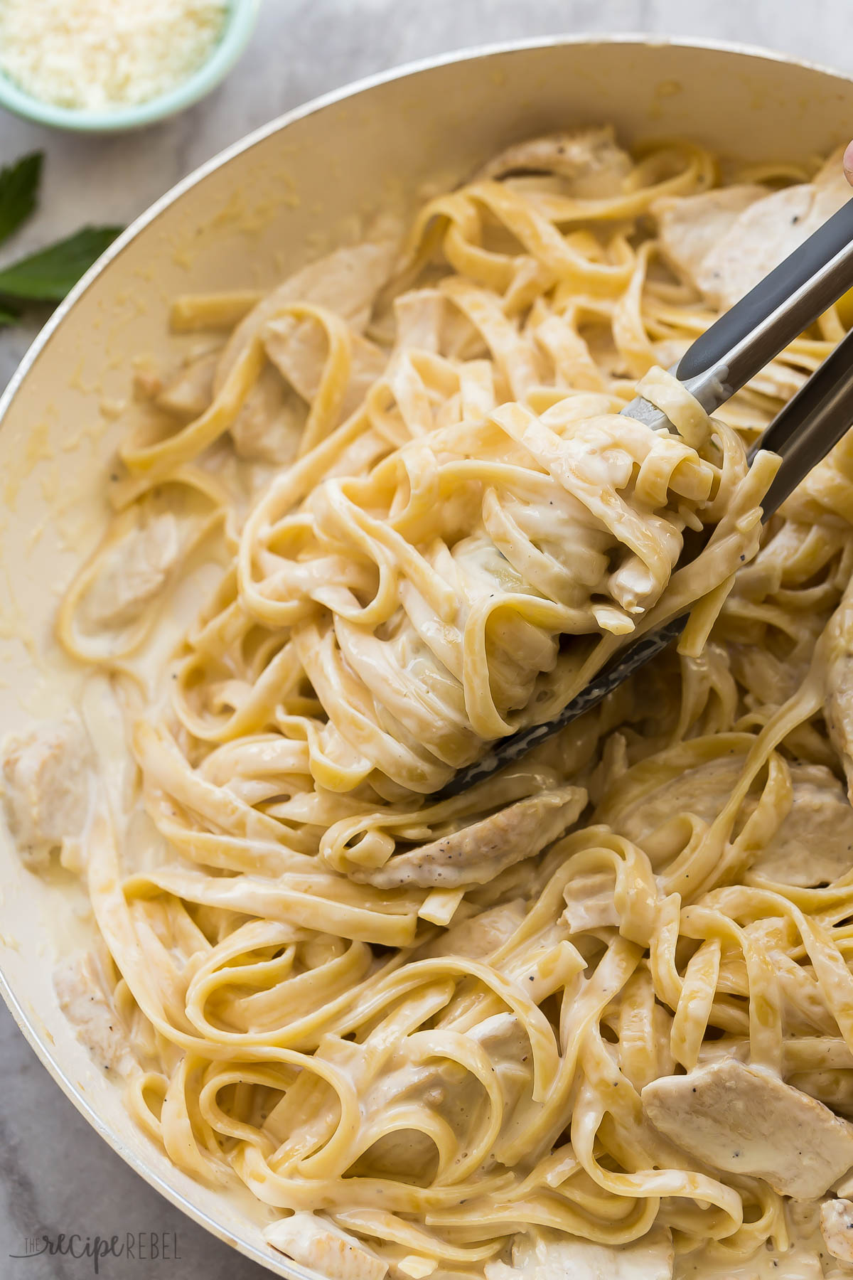 close up of fettuccine noodles twirled around tongs