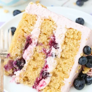 A slice of three layer blueberry crumble cake on a plate.