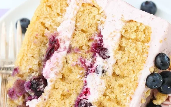 A slice of three layer blueberry crumble cake on a plate.