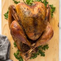whole dry brine turkey overhead on wooden cutting board with parsley