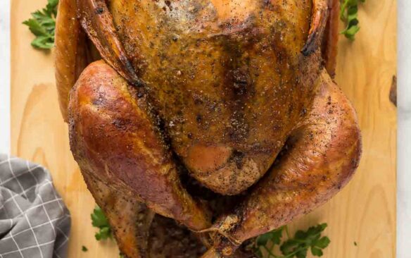 whole dry brine turkey overhead on wooden cutting board with parsley