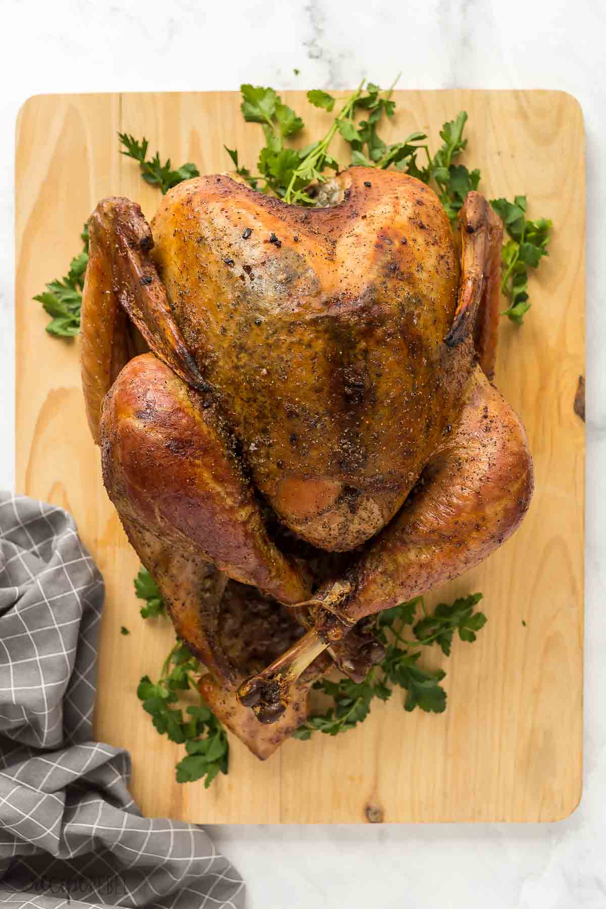 whole dry brine turkey overhead on wooden cutting board with parsley