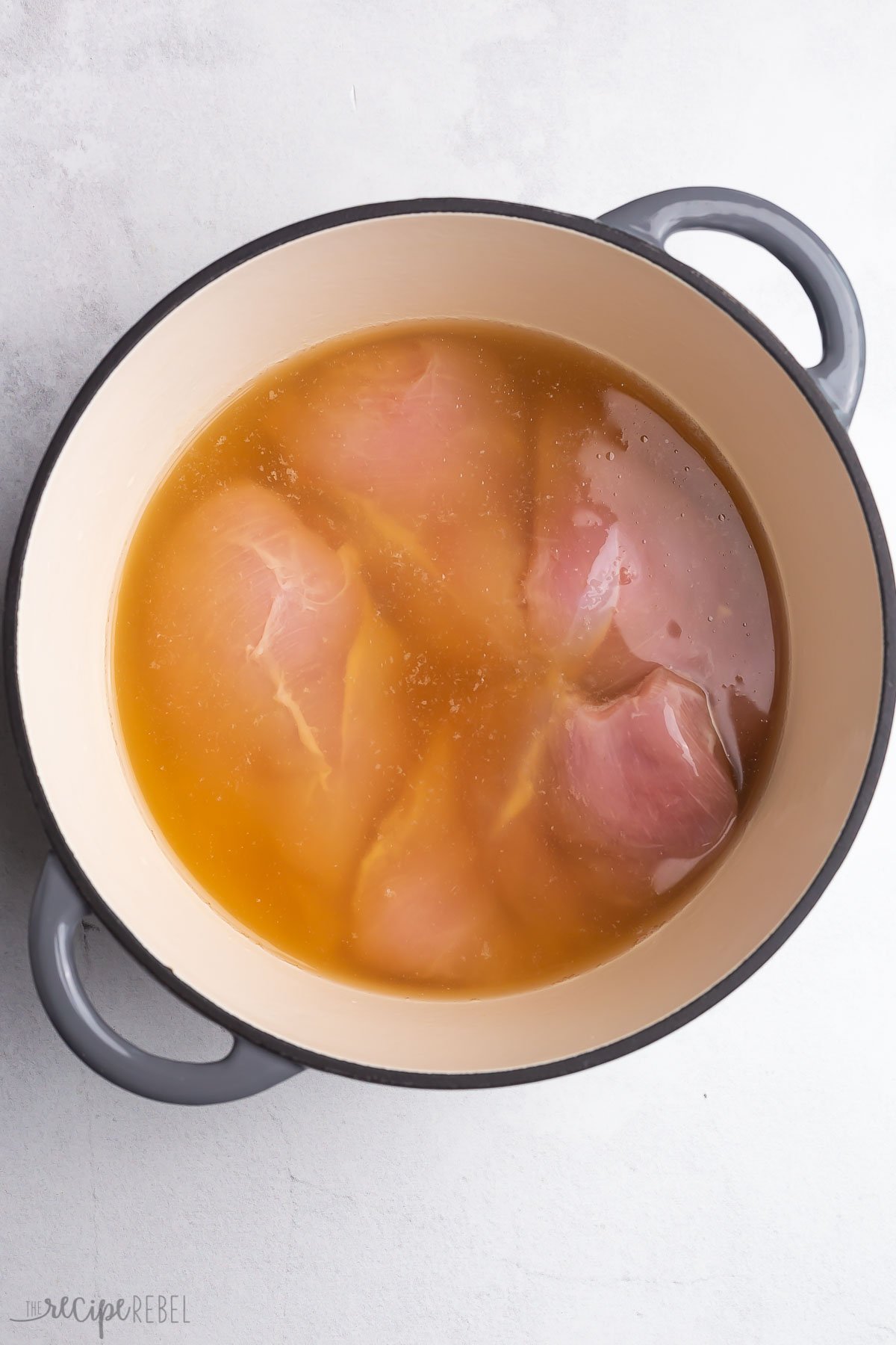 chicken breasts in chicken broth in large pot.