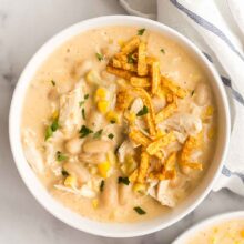 overhead image of bowl of white chicken chili with tortilla strips