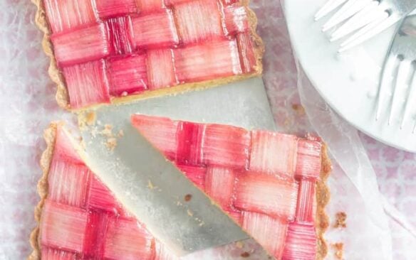 Top view of a rhubarb tart cut into slices.