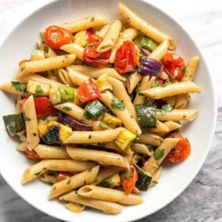 Grilled vegetable pasta salad on a white plate.