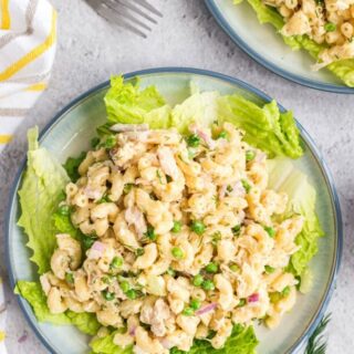 Top view of tuna pasta salad on a plate served over iceberg lettuce leaves.