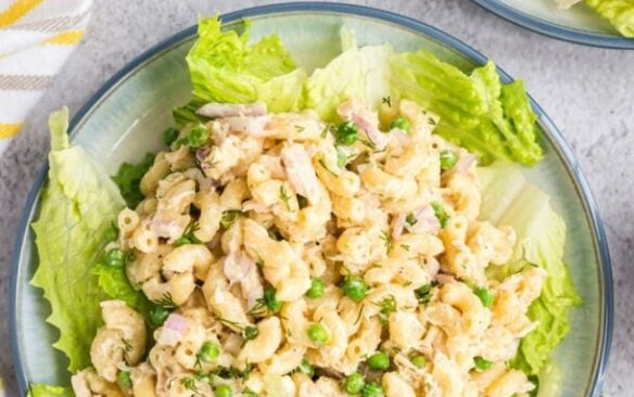 Top view of tuna pasta salad on a plate served over iceberg lettuce leaves.