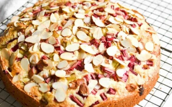 A whole rhubarb cake on a wire rack.