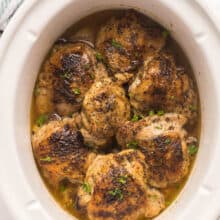 bone in slow cooker chicken thighs with crispy skin in white crockpot