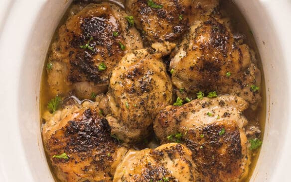 bone in slow cooker chicken thighs with crispy skin in white crockpot