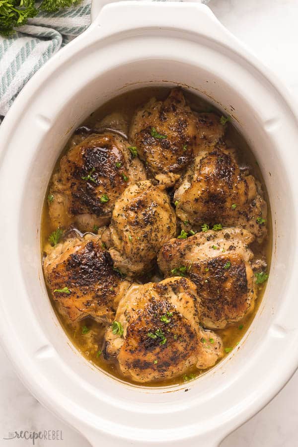 bone in slow cooker chicken thighs with crispy skin in white crockpot