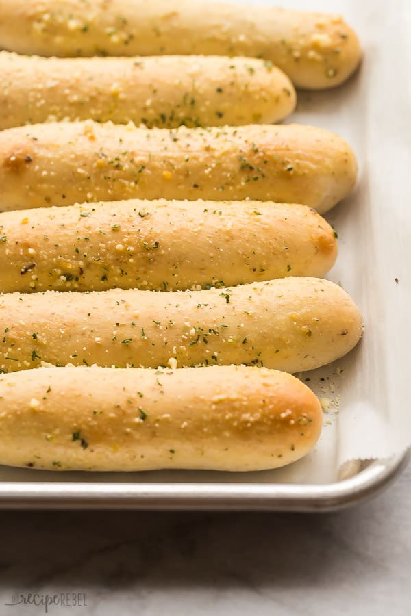 These Homemade Breadsticks are better than Olive Garden! Ready in one hour from start to finish! #breadsticks #baking #bread #recipe homemade breadsticks on a sheet pan