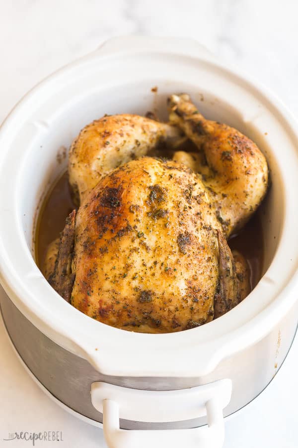 This Crockpot Whole Chicken is incredibly moist and flavorful, thanks to a coating of seasoned garlic butter and the slow cooker! The perfect make ahead weekend dinner, great for meal prepping! #crockpot #slowcooker #chicken #dinnerrecipe crockpot whole chicken in white slow cooker