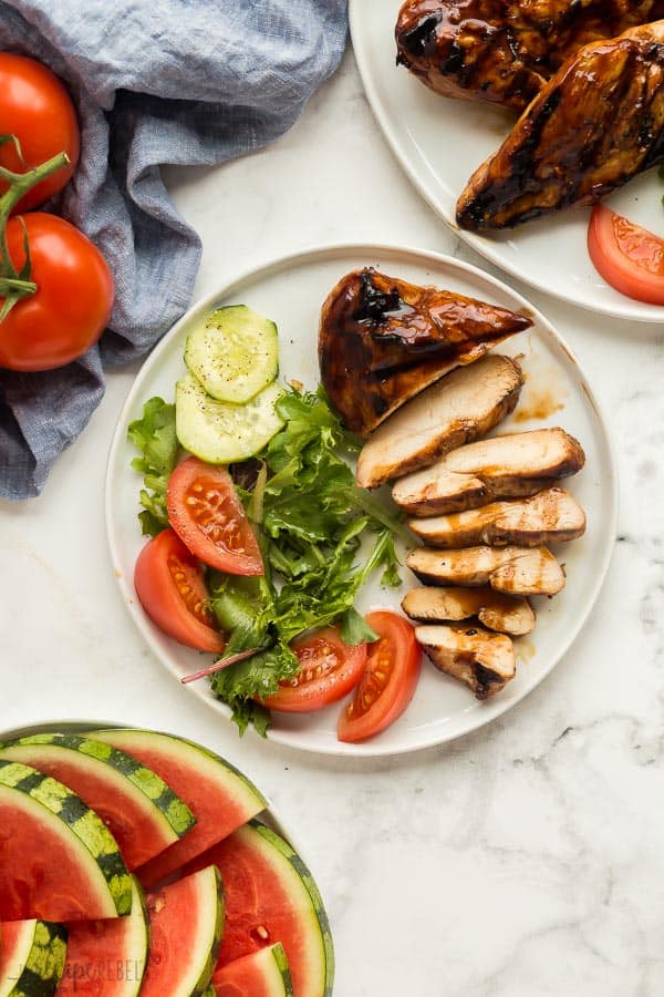 grilled chicken sliced on plate with salad