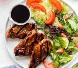 grilled chicken with marinade on white plate overhead