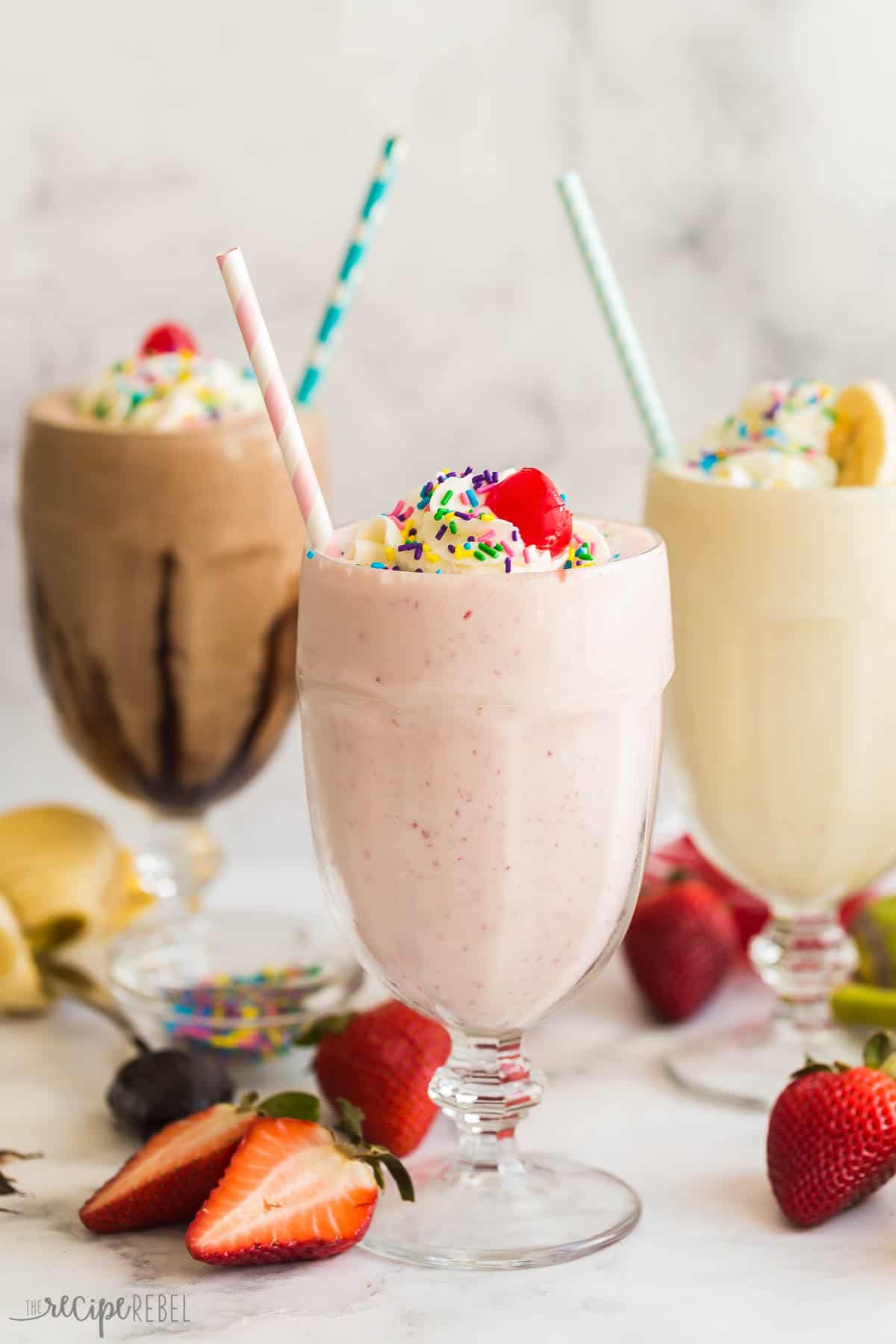 Today I'm showing you all my tips on How to Make a Milkshake! This post shows you just how easy it can be, with a simple milkshake recipe formula plus tons of variations, you'll be making a new version every day of the week. #milkshake #icecream #recipe | dessert recipes | ice cream recipes | ice cream ideas | ice cream dessert | summer dessert | summer drinks | cold drinks three milkshake flavors in glasses with whipped cream and sprinkles.