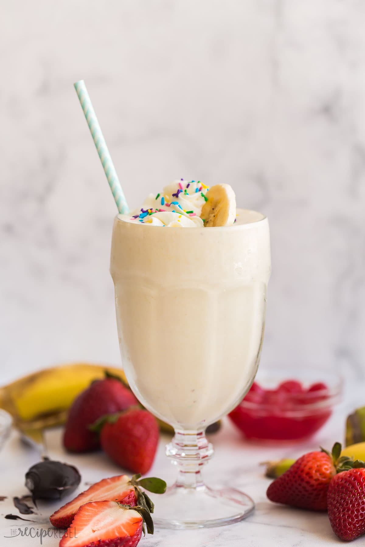 Today I'm showing you all my tips on How to Make a Milkshake! This post shows you just how easy it can be, with a simple milkshake recipe formula plus tons of variations, you'll be making a new version every day of the week. #milkshake #icecream #recipe | dessert recipes | ice cream recipes | ice cream ideas | ice cream dessert | summer dessert | summer drinks | cold drinks banana milkshake in a glass with whipped cream and sprinkles.