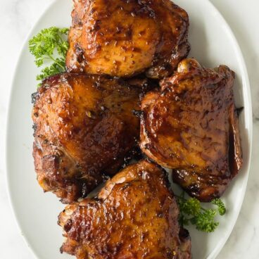 maple soy grilled turkey thighs overhead on white platter on marble background