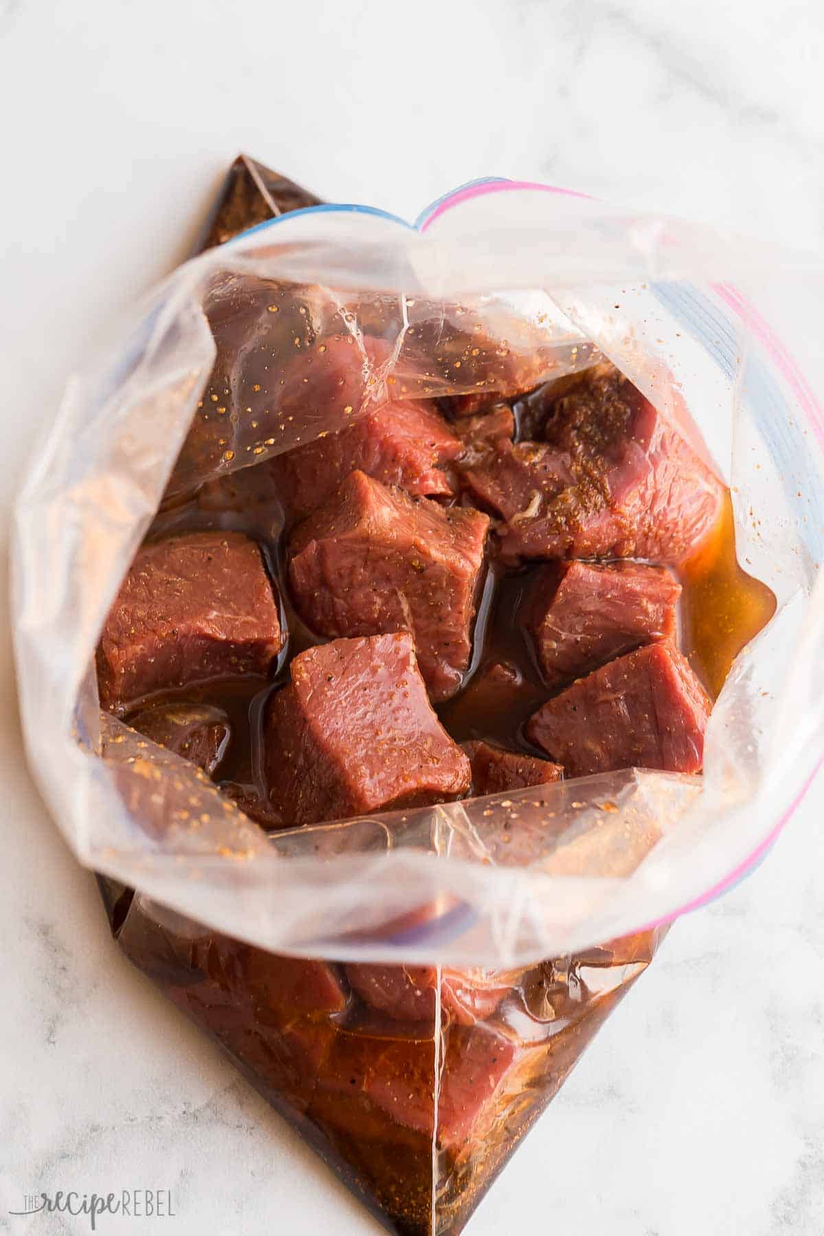 These Steak Kabobs are made with an easy marinade and loaded with tender steak, bell peppers and red onions. Easy to make and easy to prep ahead for summer entertaining! #steak #grilling #summer #recipe | summer recipes | summer dinner | grilling recipe | grilled steak | steak skewers | shish kabobs | kebabs | easy dinner ideas steak cubes in a zip top bag with marinade.