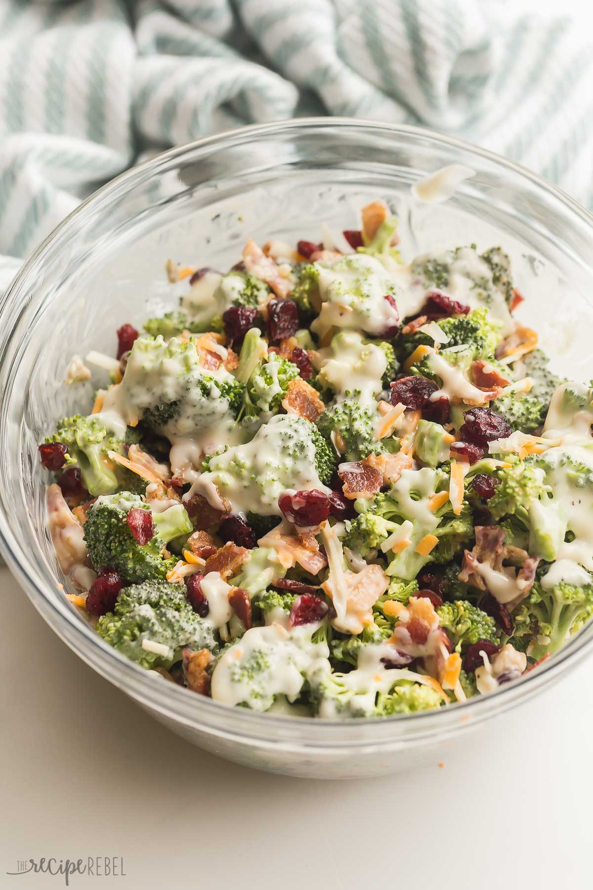close up image of broccoli salad with bacon in glass bowl.