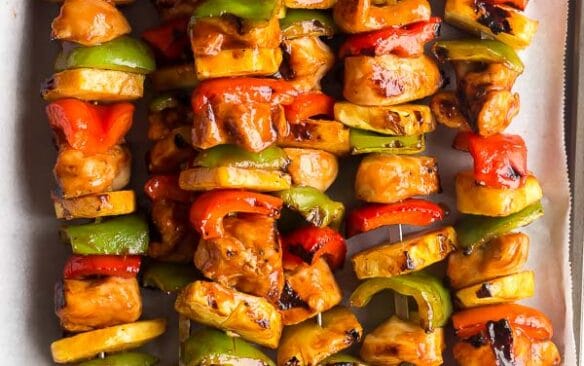 hawaiian chicken kabobs cooked with pineapples and peppers on sheet pan