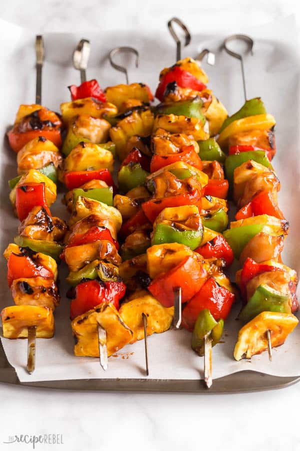 hawaiian chicken kabobs close up on skewers with pineapples and peppers