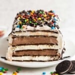 square image of whole ice cream sandwich cake with M&Ms and chocolate sauce.