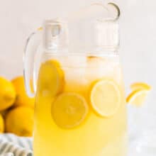 homemade lemonade recipe in large glass pitcher with lemon slices
