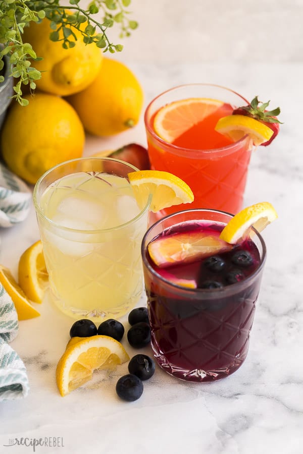 lemonade, strawberry lemonade, blueberry lemonade all in glasses with lemon slices