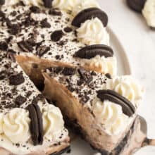 oreo ice cream cake whole with slice being pulled out on white plate