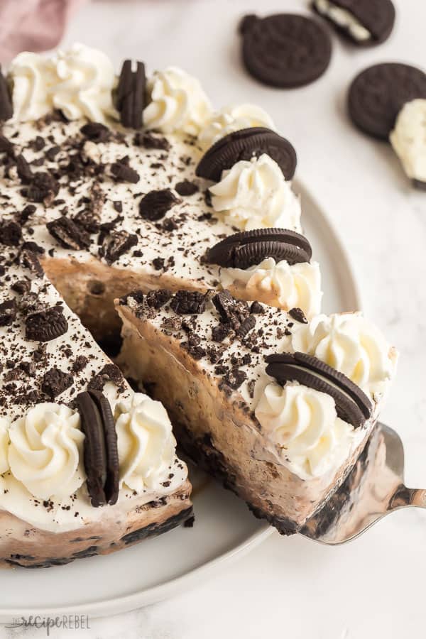 oreo ice cream cake whole with slice being pulled out on white plate